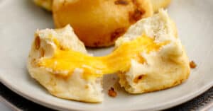 Cheesy Onion Pull Apart Bread Cut in Half with Melty Cheese Inside on a Plate