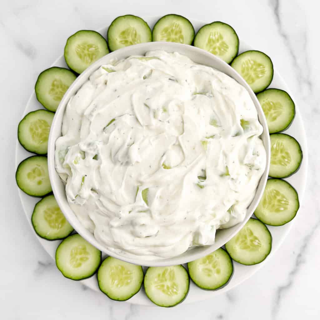 Cucumber Dip in a Bowl with Cucumber Slices Around It on a Plate