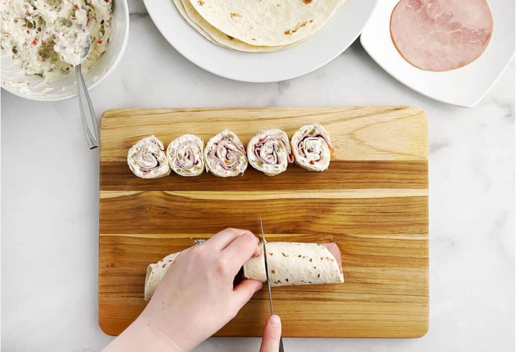 Cut Tortilla Rollup in Slices on Cutting Board with Knife