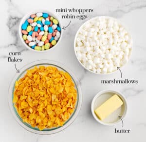 Bowls of Corn Flakes, Marshmallows, Butter, and Whopper Robin Egg Candy on White Marble Surface