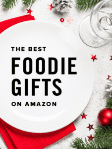 The Best Foodie Gifts on Amazon Text Overlay on Plate with Red Napkin and Wintry Christmas Table Spread