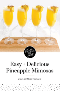Pineapple mimosas with pineapple chunk garnishes on a tray
