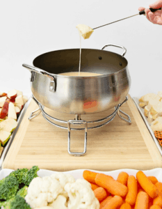 Dipping bread into cheddar cheese fondue pot
