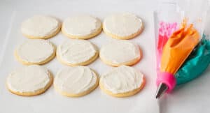Frosted white sugar cookies with tri color piping bag