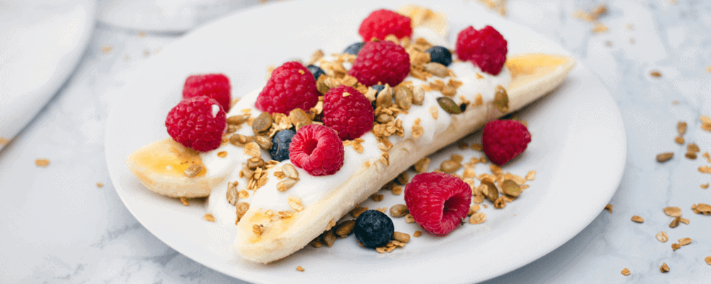 Banana Split with Yogurt, Berries, and Granola on a Plate