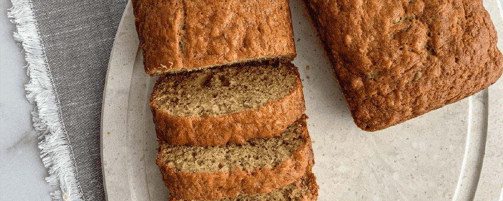 Banana Bread Sliced on a Cutting Board with a Dish Towel Underneath