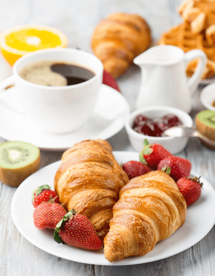 Table Setting Breakfast Spread with Coffee and Croissants with Strawberries