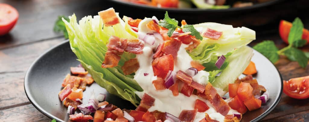Plated Wedge Salad with Lettuc, Bacon Bits, Tomatoes, and Dressing
