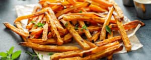Sweet Potato Fries on a White Platter with Fresh Herbs