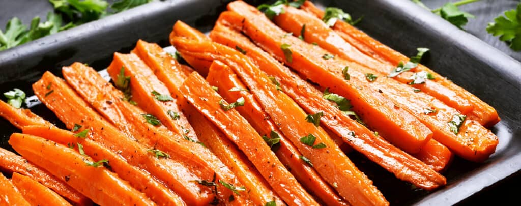 Glazed Carrots in a Baking Dish Topped with Fresh Herbs