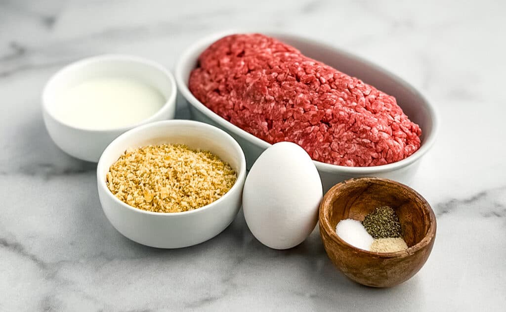 Meatball Ingredients Including Ground Beef, Milk, Crushed Cracker Crumbs, Egg, Salt, Pepper, Onion Powder