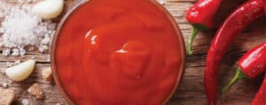 Hot Sauce in a Bowl with Fresh Peppers Surrounding