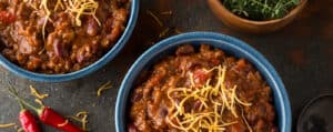 Bowls of Chili with Shredded Cheddar and Toppings