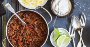 Pot of Chili with Chili Toppings and Utensils