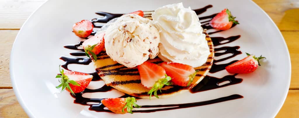 Pancakes Topped with Whipped Cream Chocolate Syrup and Strawberries