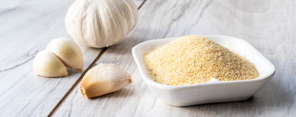 Garlic Powder in a Bowl with Garlic Cloves