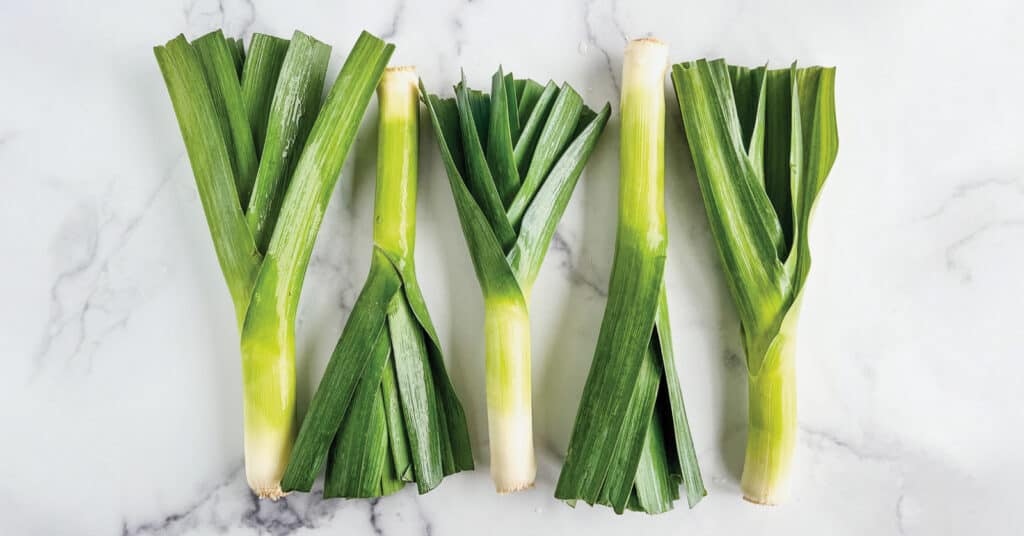 Five Leeks on a White and Grey Marble Countertop