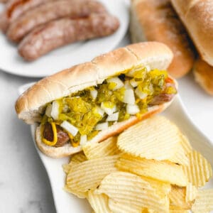 Brat with Toppings on a Bun with Chips