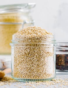 Raw Quinoa in a Glass Jar with Quinoa on the Countertop
