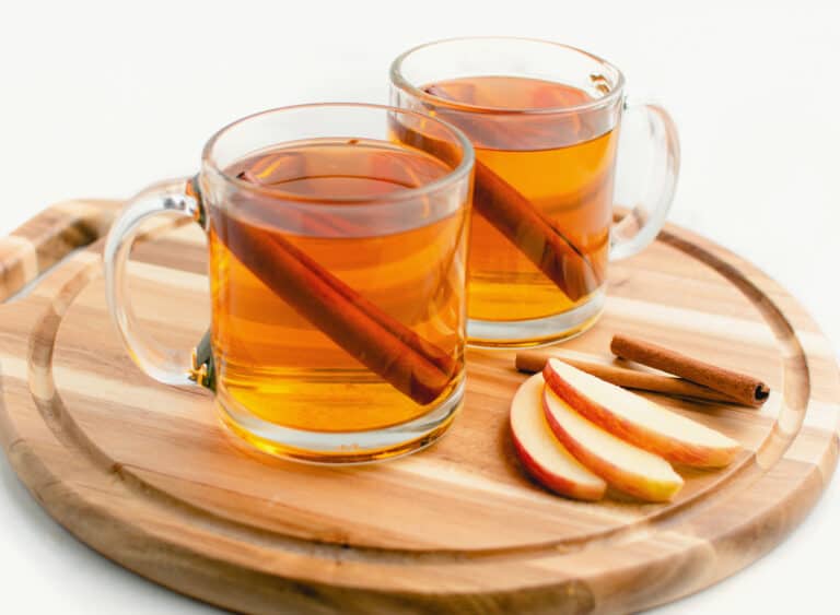 Hot Apple Cider in Glass Mugs with Cinnamon Sticks and Apple Slices