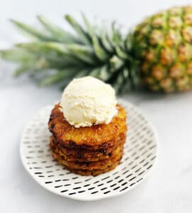 Cinnamon Brown Sugar Air Fried Pineapple Rings Topped with Ice Cream with a Whole Pineapple in the Back