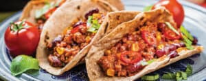 Chili Tacos on a Plate with Tomatoes and Fresh Herbs
