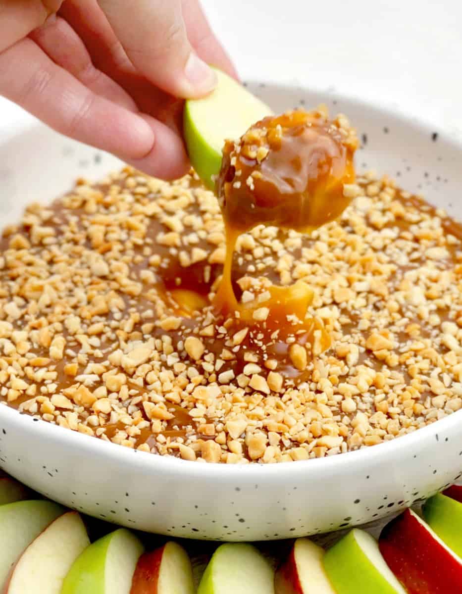 Caramel Apple Dip with Peanuts in a Bowl with Green and Red Apple Slices