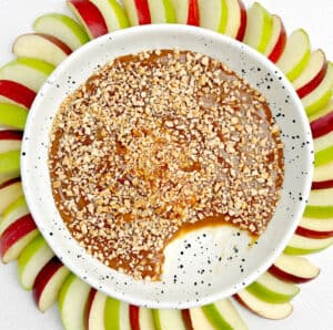 Caramel Apple Dip in Bowl with Scoop Gone and Red and Green Apples Fanned Around the Bowl