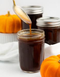Pumpkin Spice Syrup in a Mason Jar with Small Pumpkins in Background