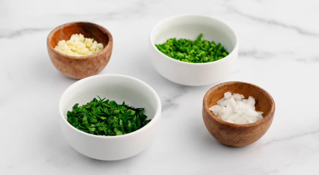 Chopped Herbs, Onions, and Garlic in Bowls