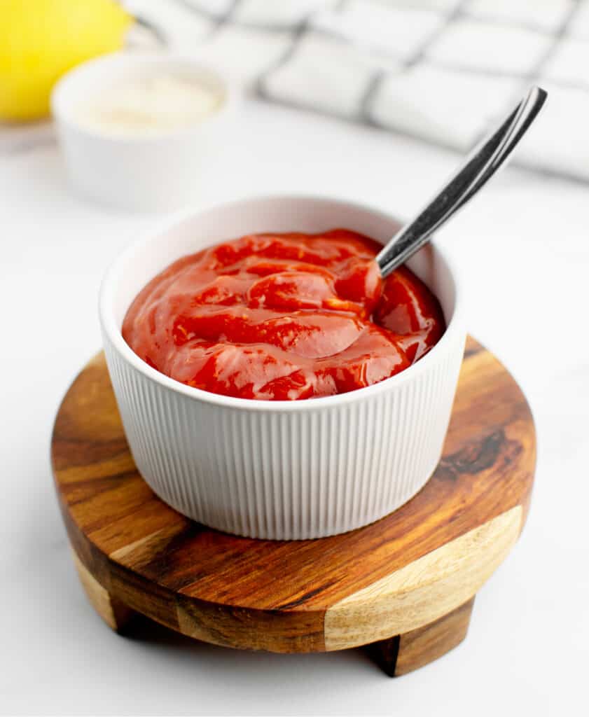 Homemade Cocktail Sauce in Bowl with Spoon on Wooden Coaster