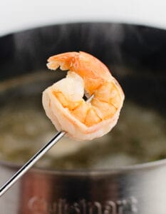 Shrimp on Fondue Stick with Fondue Pot in the Background