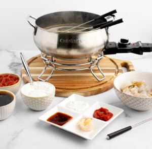 Fondue Pot of Flavored Broth with Bowl of Raw Shrimp, Dipping Sauces, Fondue Forks, Plate with Sauces