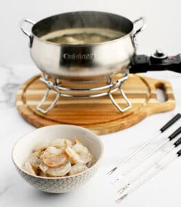 Raw Shrimp in Bowl Next to Fondue Pot with Flavored Broth