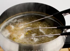 Shrimp Cooking in Flavored Broth in Fondue Pot