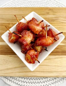 Bacon Wrapped Water Chestnuts Finished in Square Bowl on Wooden Surface