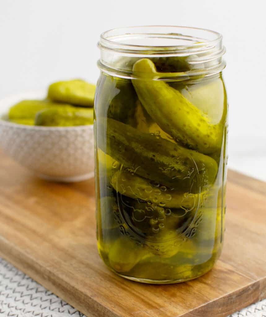 Dill Pickles in Jar with Bowl of Pickles in the Background