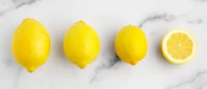 Different Sizes of Lemon Large, Medium, Small, and Half Lemon on White Marble Surface