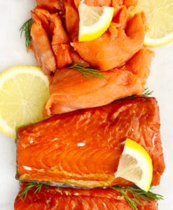 Smoked Salmon with Lemon and Herbs on White Surface