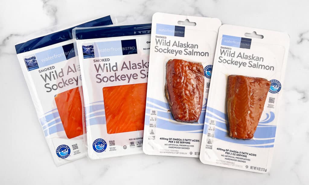 Hot Smoked Salmon and Cold Smoked Salmon in Packaging on White Marble Surface