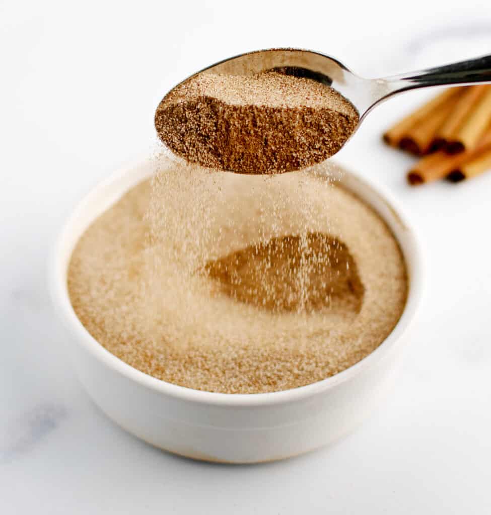 Cinnamon Sugar in Bowl with Spoon Sprinkling Spice Back Into Bowl