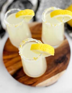 Lemon Drop Shots Garnishes with Lemon Wedge on Wooden Surface