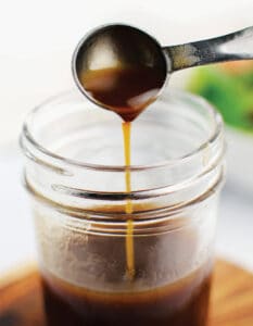 Dijon Balsamic Vinaigrette in a mason jar with a measuring spoon