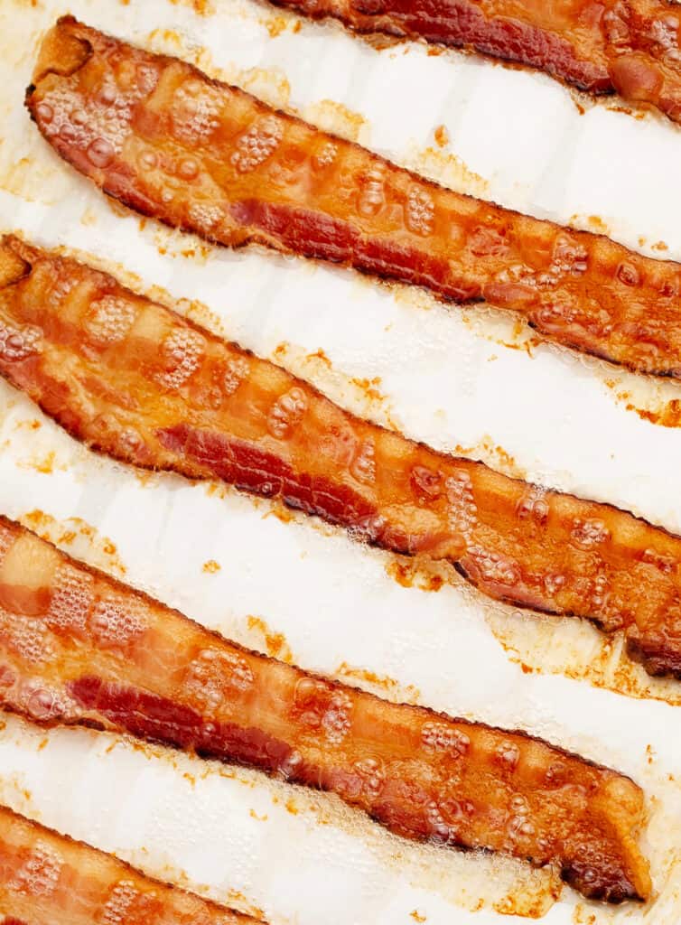 Sizzling Bacon Diagonally on Pan with Parchment Paper