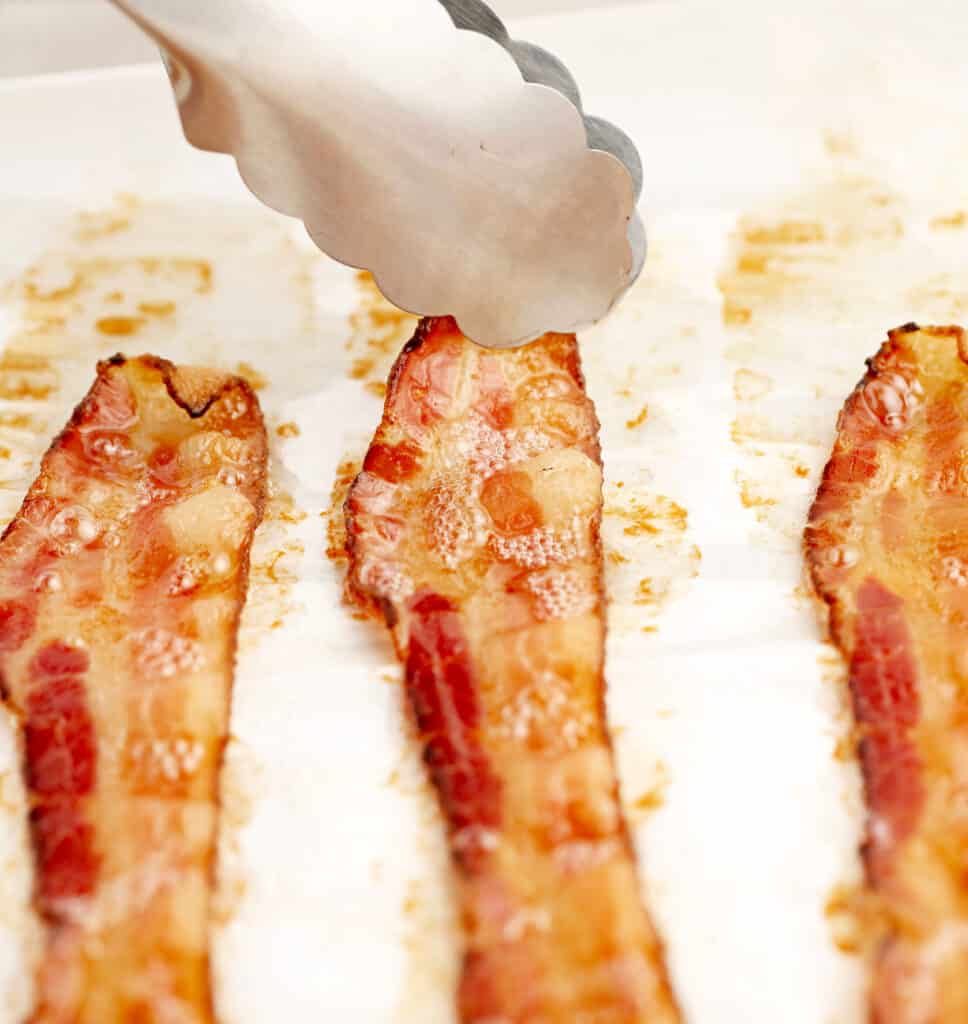 https://northernyum.com/wp-content/uploads/2023/06/How-to-Cook-Bacon-in-the-Oven_Blog-Image9_tongs-968x1024.jpg