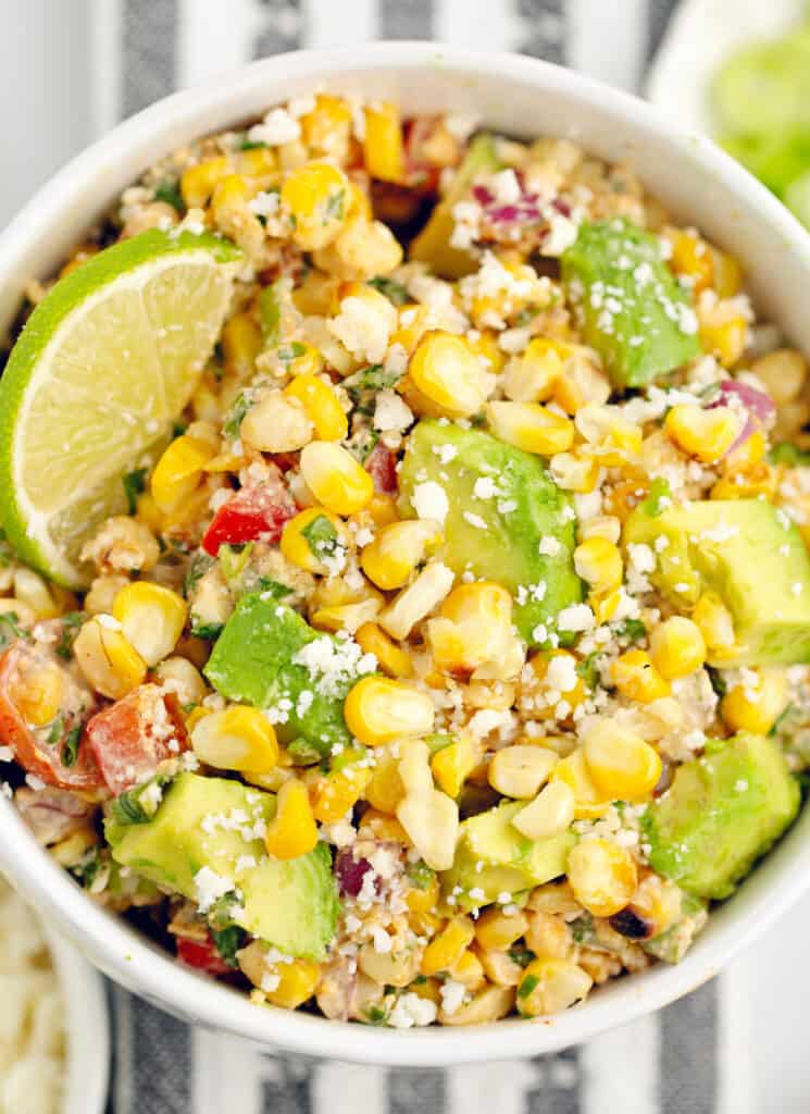 Closeup of Corn Salad with Cojita Cheese, Cilantro, Lime Wedges