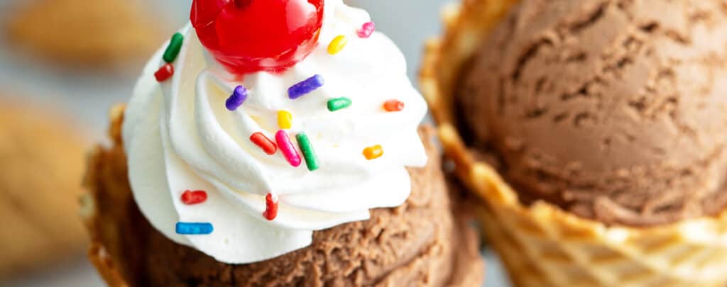 Whipped Cream with Sprinkles and Cherry on Chocolate Ice Cream