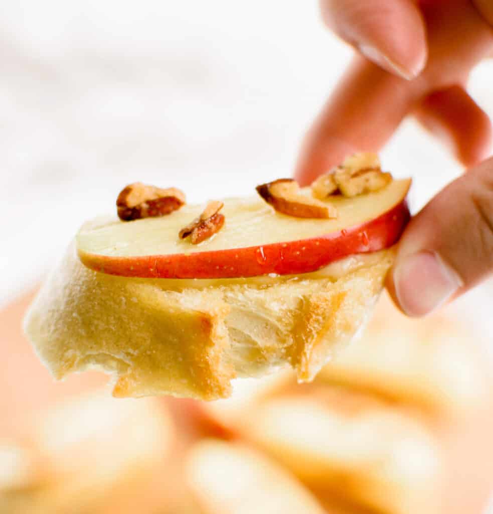 Hand Holding a Apple Brie Crostini Closeup