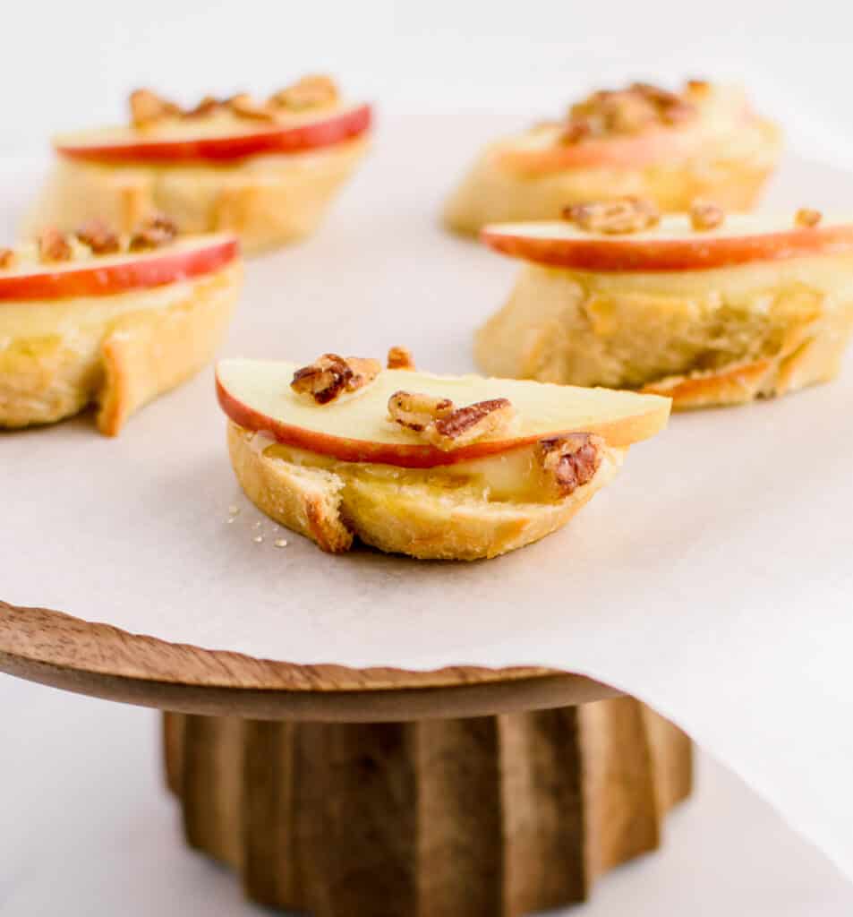 Brie Apple Appetizers on Parchment on Wooden Cake Stand