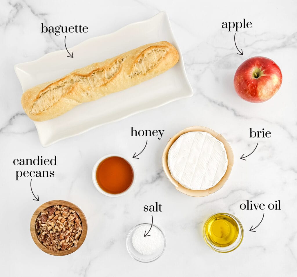 Ingredients for Brie and Apple Crostini Appetizers on White Marble Surface